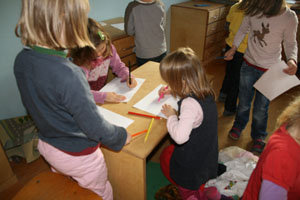 Kinder am Tisch zeichnen Baupläne für Maschinen